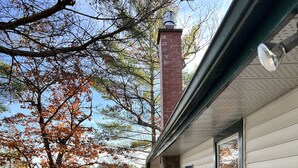 A cabin with a stone foundation, a chimney, and a window overlooking a lake. - Historic but HiTech, modern Burleigh Falls cottage on Stony Lake. Amazing views (Harcourt)