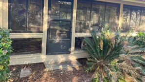 A house with a covered porch, large windows, and a door. - Dataw Island Golf Villa (Saint Helena Island)