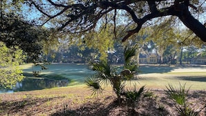 A serene golf course with a pond, surrounded by trees and a clear sky. - Dataw Island Golf Villa (Saint Helena Island)