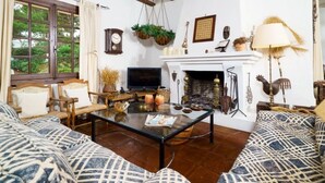 A living room with a fireplace, wooden furniture, and a television. - Chalet in El Portet (Moraira)