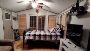 A bedroom with a bed, a TV, a fireplace, and a ceiling fan. - Riverfront Romantic Getaway (Andrews)