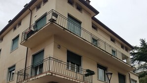 A multi-story building with a ground-level entrance, balconies with metal railings, and a sign reading "CA DEI GRECI". - Le Maschere  (Mestre)