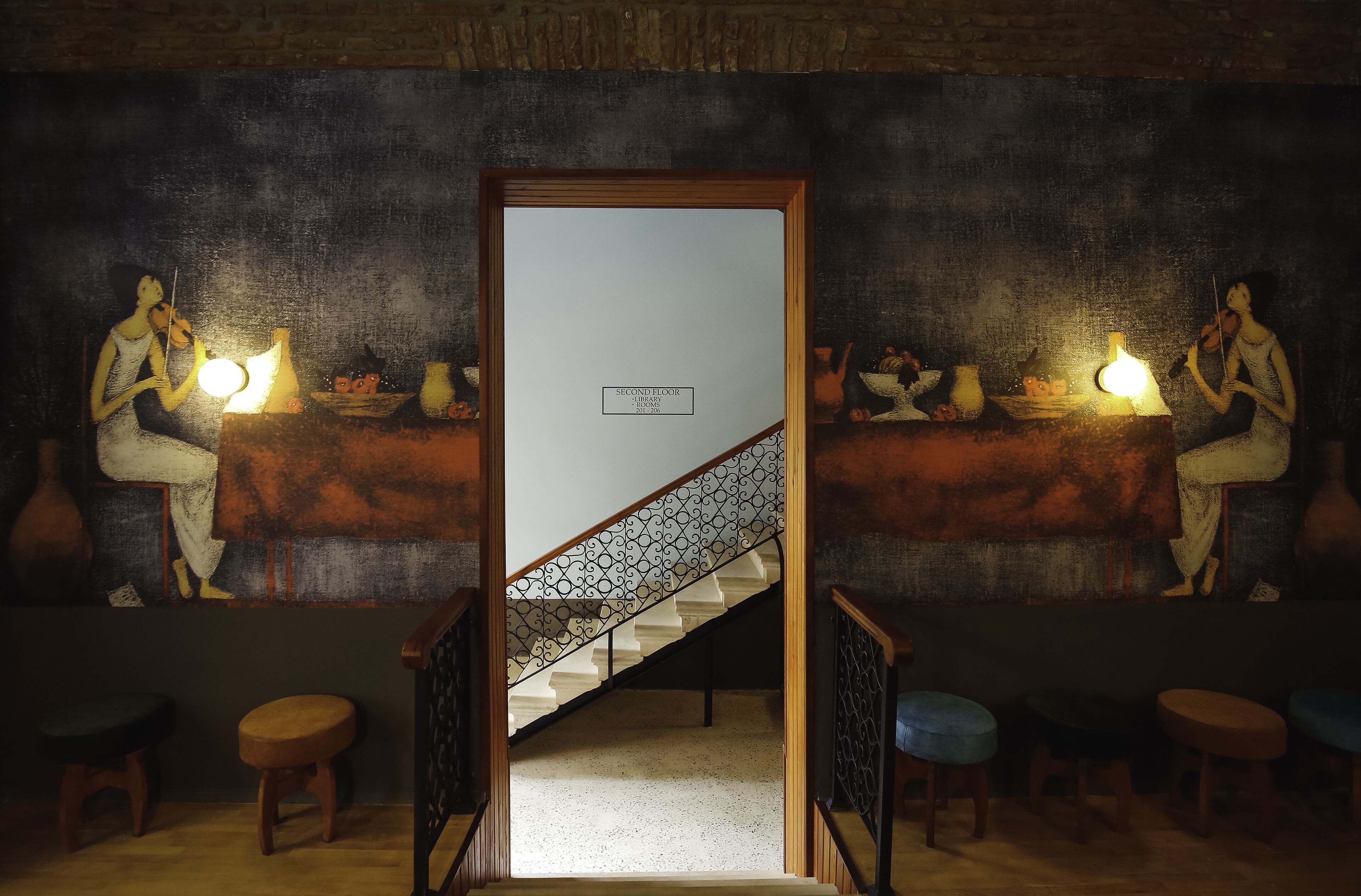 A staircase leading to the second floor with a framed artwork depicting two figures playing violins.