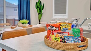 Un comptoir de cuisine avec un panier contenant des en-cas comme des Doritos, des Cheetos et de l’eau pétillante Kirkland.