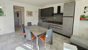 A modern kitchen with dark cabinets, a built-in oven, and a gas stove.