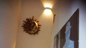 A staircase with a decorative wall piece and a framed picture.