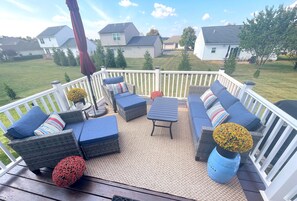 A covered outdoor deck with wicker furniture, a table, and decorative vases. - Cozy 4 Bedroom 3 Bath, 3 miles from PSU campus/downtown in quiet neighborhood  (State College)