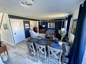 A modern living room with a sofa, a dining table with chairs, and a TV. - Cozy 4 Bedroom 3 Bath, 3 miles from PSU campus/downtown in quiet neighborhood  (State College)