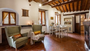 Une pièce chaleureuse avec un plafond en bois, un coin repas avec une table et des chaises, et une cheminée.