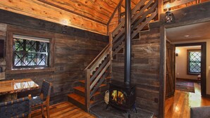 A wooden interior with a fireplace, a staircase, and a dining area. - Vikings Villages Resort (Guilford)