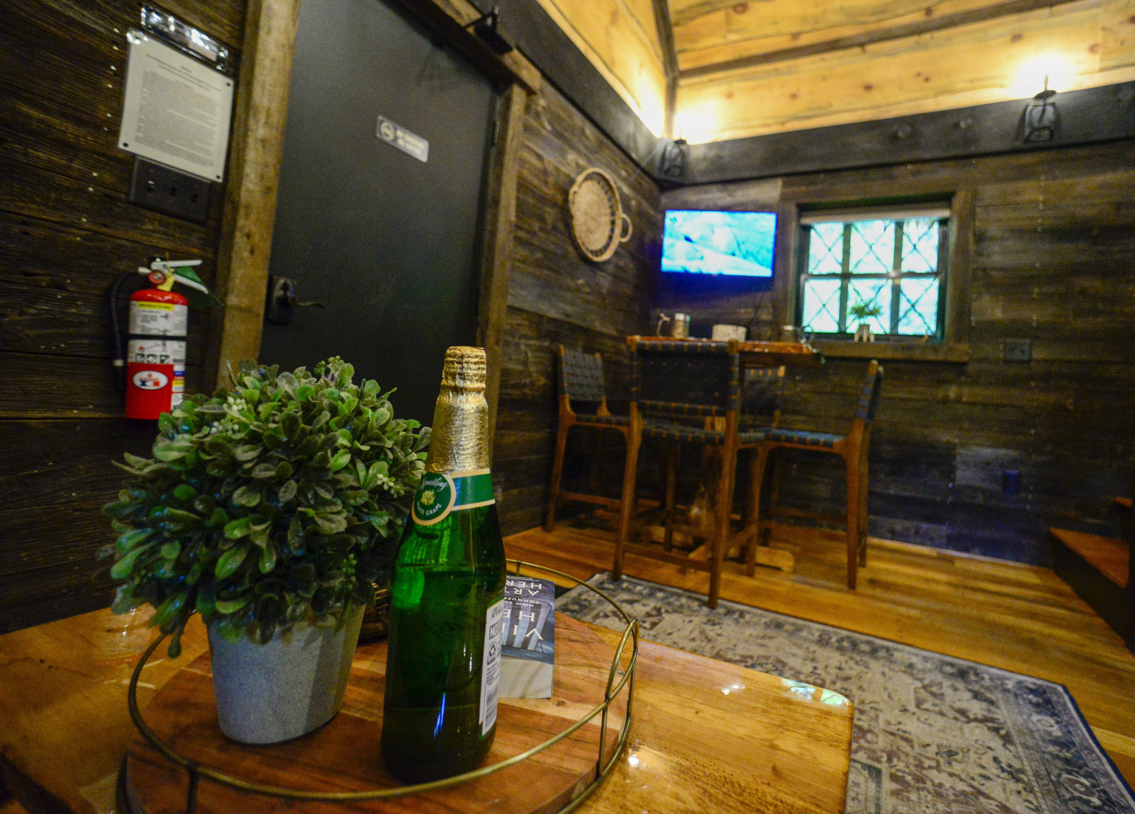 Un interior de madera con una zona de bar, un televisor y un extintor.