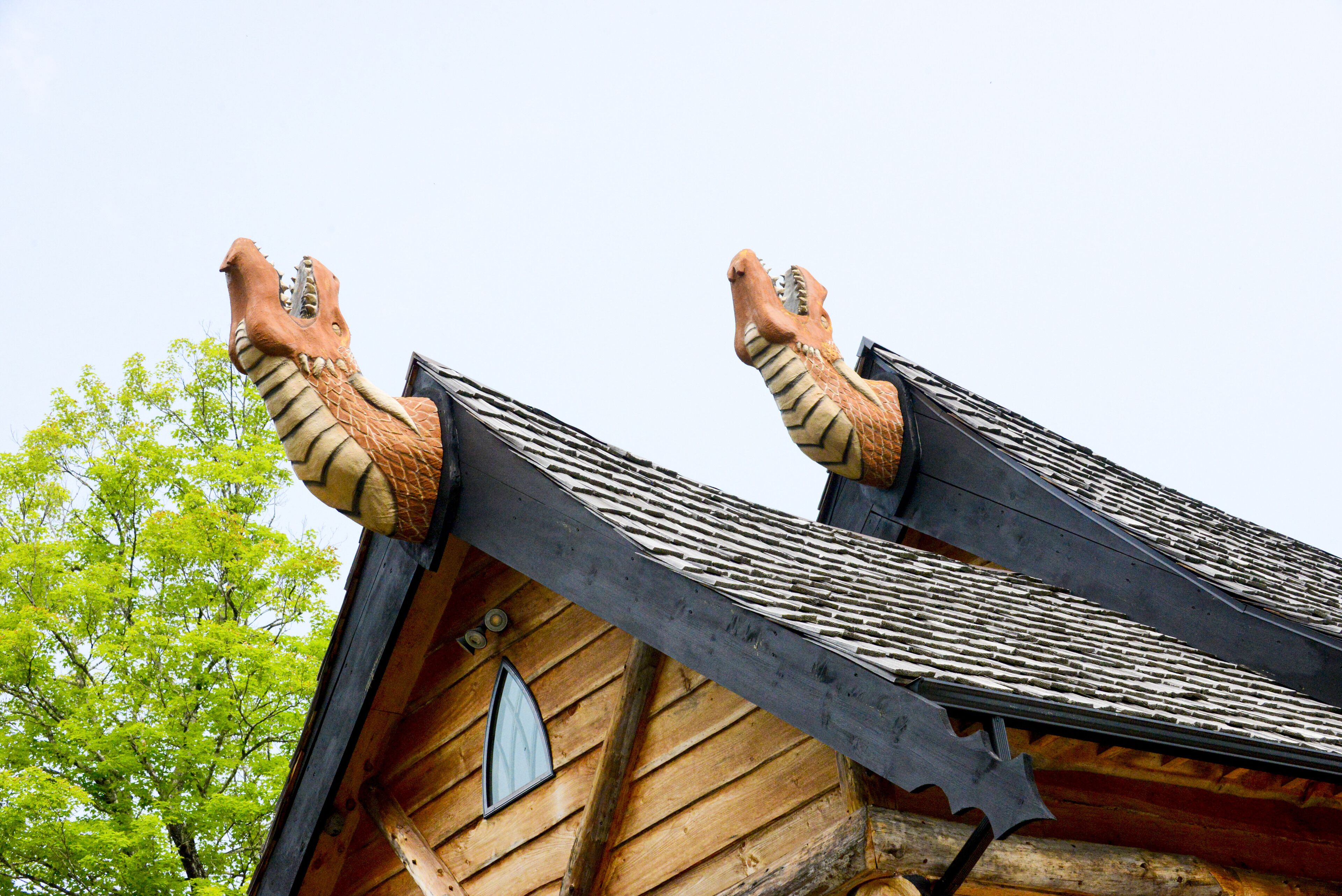 A building with a steeply pitched roof and two large, dragon-like sculptures at the peak.