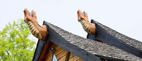 A building with a steeply pitched roof and two large, dragon-like sculptures at the peak.