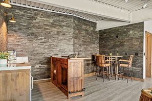 A room with a stone wall, wooden furniture, and a bar area.