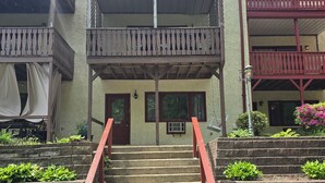 A building with a central staircase, a door with a number, and a balcony with a railing. - Paul's Apartment - 55in TV, Wi-Fi, kitchenette (Helen)