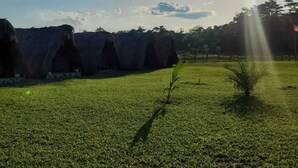 Um campo gramado com grandes formações rochosas e céu claro.