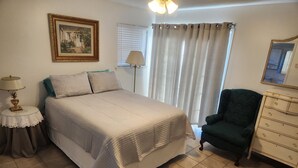 A neatly arranged bedroom with a bed, a chair, a dresser, a lamp, and a painting on the wall. - The hunt club (Tulsa)