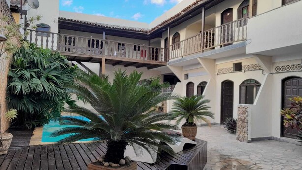 Ein Innenhof mit Pool, Kübelpflanzen und einer Holzterrasse.