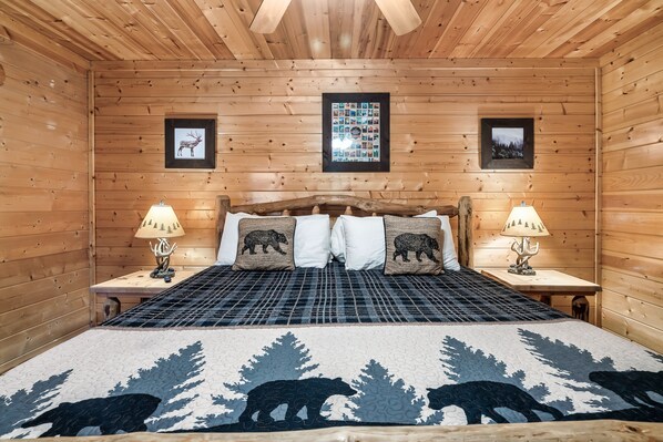 Una habitación con paneles de madera, una cama, dos mesitas de noche y cuadros colgados en la pared.