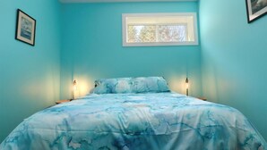 Un dormitorio con una cama, dos lámparas de noche y una ventana.