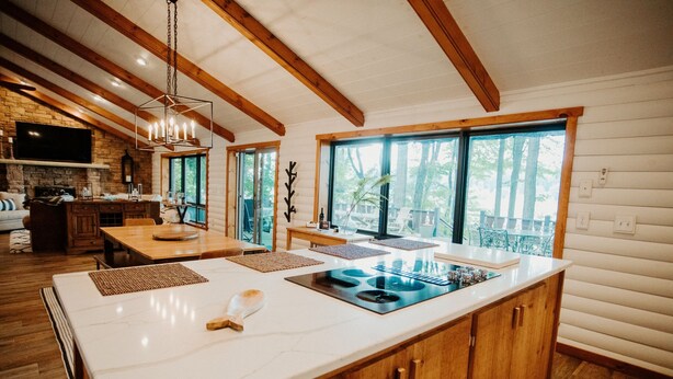 Una cocina amplia con una isla grande, armarios de madera y una chimenea de piedra.
