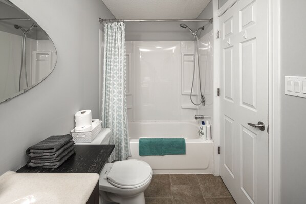 A bathroom with a toilet, sink, and bathtub.