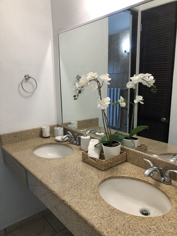 A bathroom with two sinks, a mirror, and a potted orchid. - Paradise Found In Culebra PR With Incredible Caribbean Sea View (Culebra)