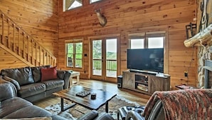 A wooden interior with a sofa, coffee table, and television.