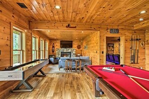 A wooden cabin interior with a pool table, billiards, a fireplace, and a cinema sign. - Blue Ridge Luxury Cabin w/ Views, Movie Theater, EV Charger & Hot Tub (Morganton)