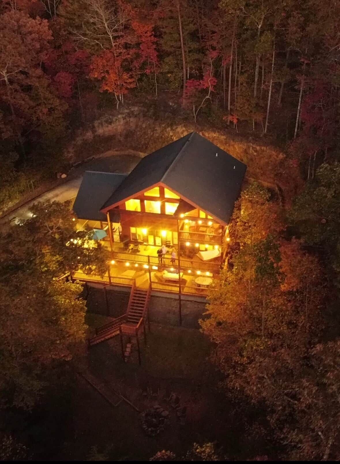 A lodge with a prominent roof and a deck area, surrounded by trees.