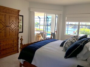 Relax in this serene bedroom with a large bed, wardrobe, and access to the outdoor pool.