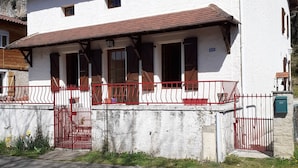A two-story building with a white exterior and a red-tiled roof.