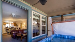 Quarto com hidromassagem, área de jantar e sala de estar com sofá de couro e mesa de centro.