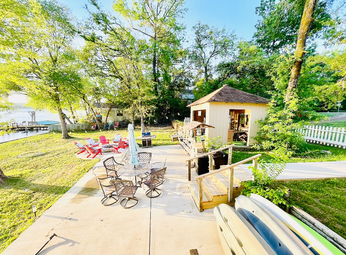 Un espace extérieur aménagé avec du mobilier de jardin, un petit bâtiment et un bateau.
