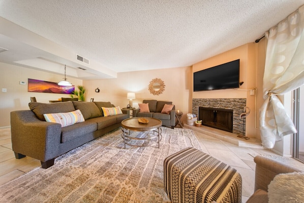 A living room with a sofa, coffee table, and fireplace.