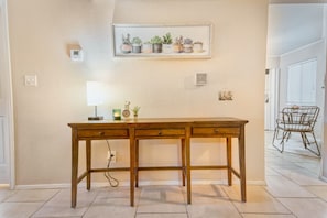 A wooden desk with drawers, a lamp, and a small plant on the wall. - The Cactus Flower at McCormick Ranch (Scottsdale)