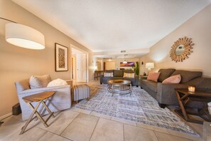 A modern living room with a sofa, a coffee table, and a rug. - The Cactus Flower at McCormick Ranch (Scottsdale)