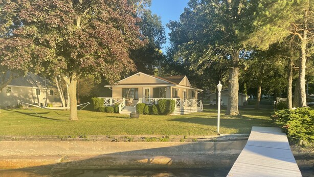 A house with a front yard, a wooden deck, and a small pond. - Lake Frontage, swimming area, close to golf (Markesan)