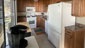 A kitchen with wooden cabinets, a white refrigerator, a stove, and a microwave. - Lake Frontage, swimming area, close to golf (Markesan)