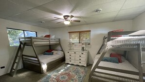 A room with bunk beds, a ceiling fan, a dresser, and a window with blinds. - Lake Frontage, swimming area, close to golf (Markesan)