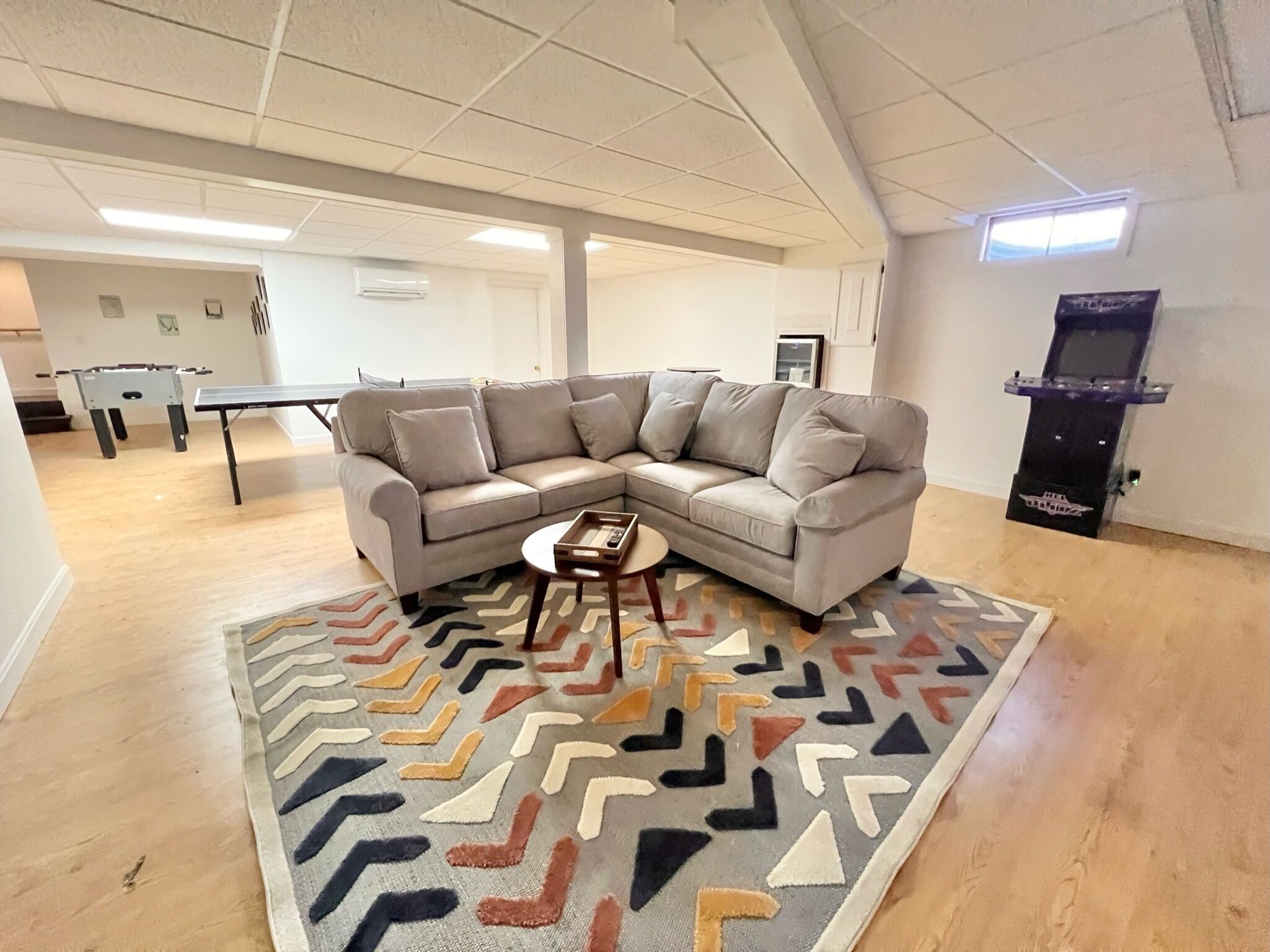 A living room with a sectional sofa, a coffee table, and a patterned rug.