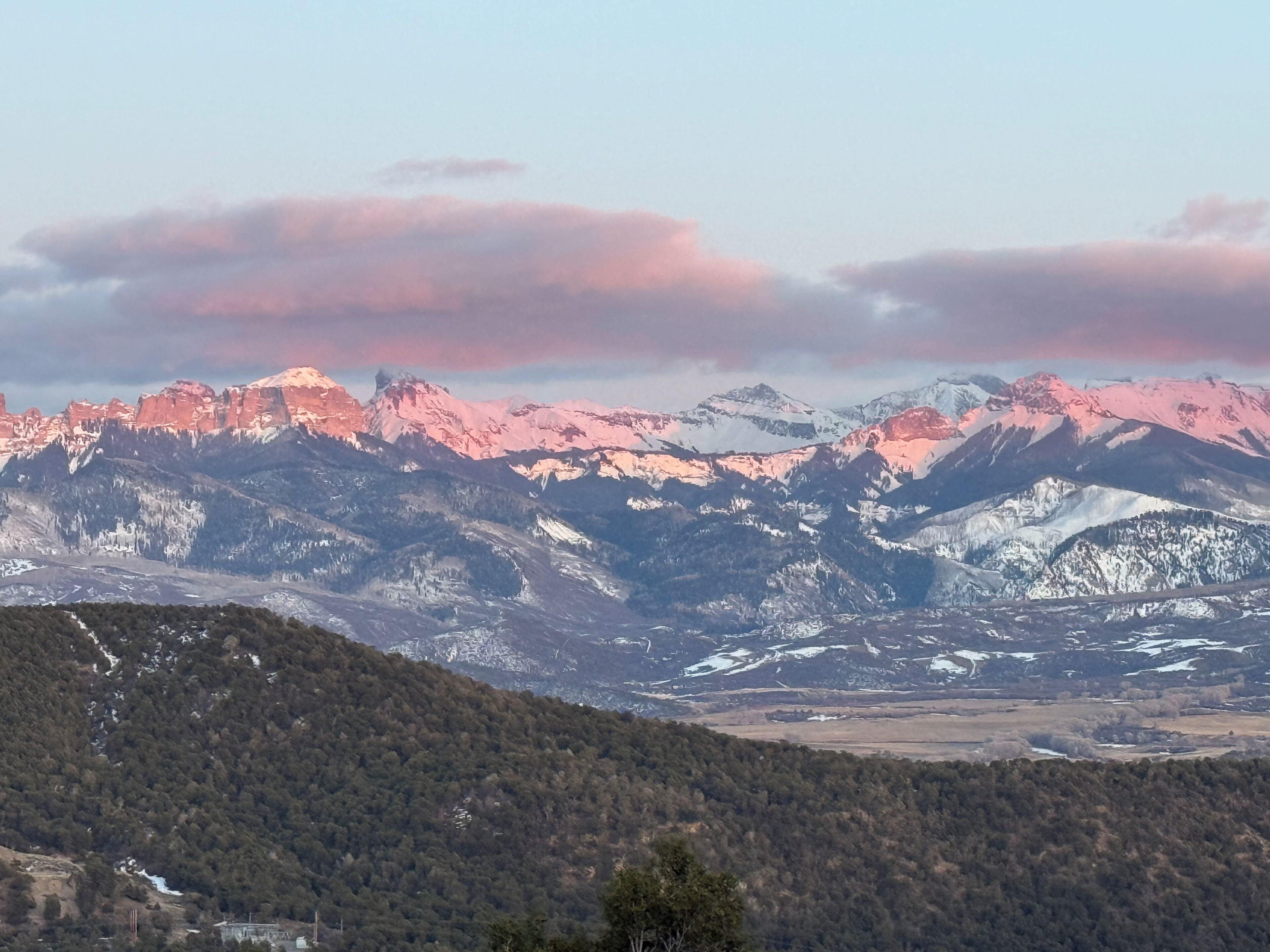 A mountainous landscape with snow-capped peaks and a valley below.