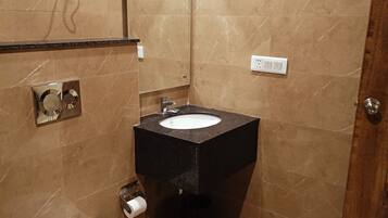 Een kleine badkamer met toilet, wastafel en douche.