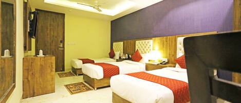 A hotel room with two beds, a wooden headboard, a ceiling fan, and a small wooden dresser.