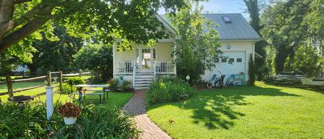 A house with a front porch, a pathway leading to the entrance, and a bicycle parked outside.