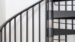 A black spiral staircase with a metal railing. - BRAND NEW downtown TC rooftop condo skyline views (Traverse City)