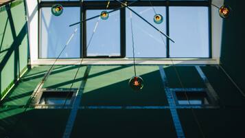 A room with a large window, a hanging light fixture, and a visible ceiling structure.