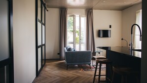 Una sala de estar moderna con un sofá, una mesa de centro y un televisor montado en la pared.