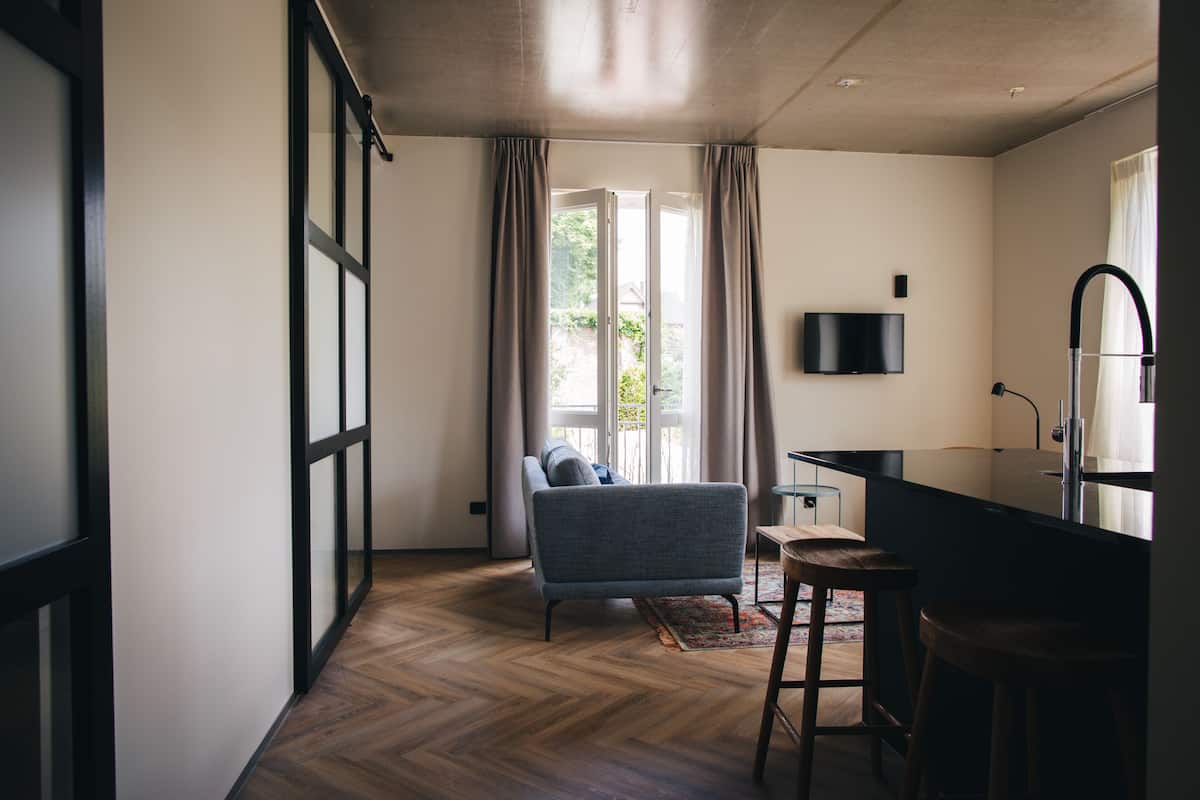 Una sala de estar moderna con un sofá, una mesa de centro y un televisor montado en la pared.