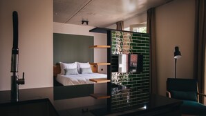 Una habitación de hotel moderna con una cama, un escritorio y una silla.